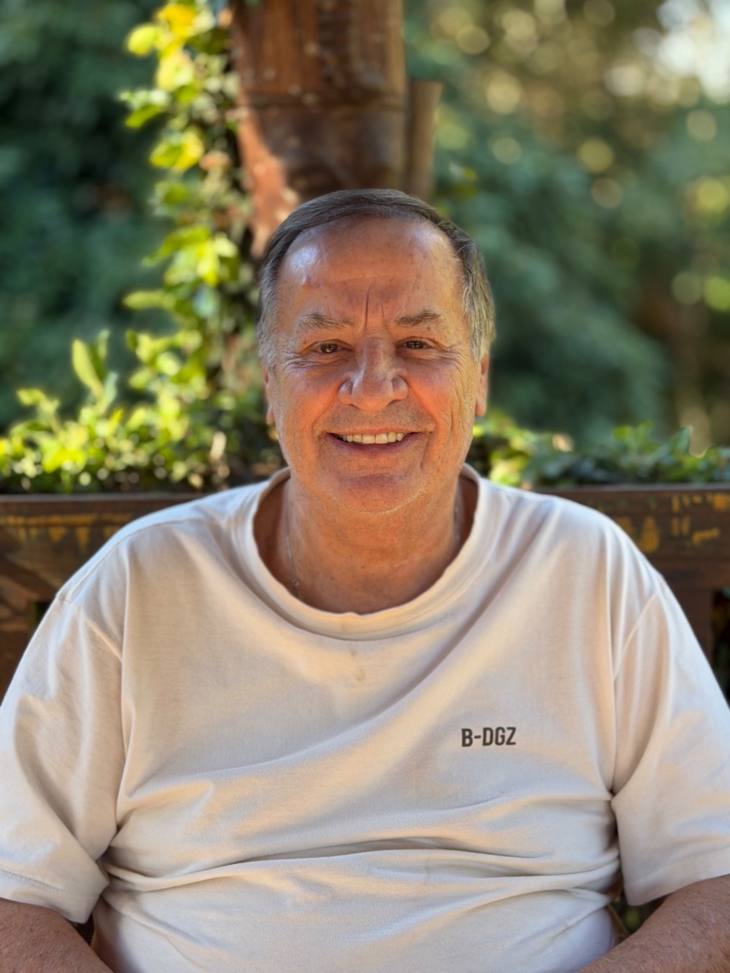 Sr. E, atendido pela Dellavita em Barueri, sorrindo no jardim de casa
